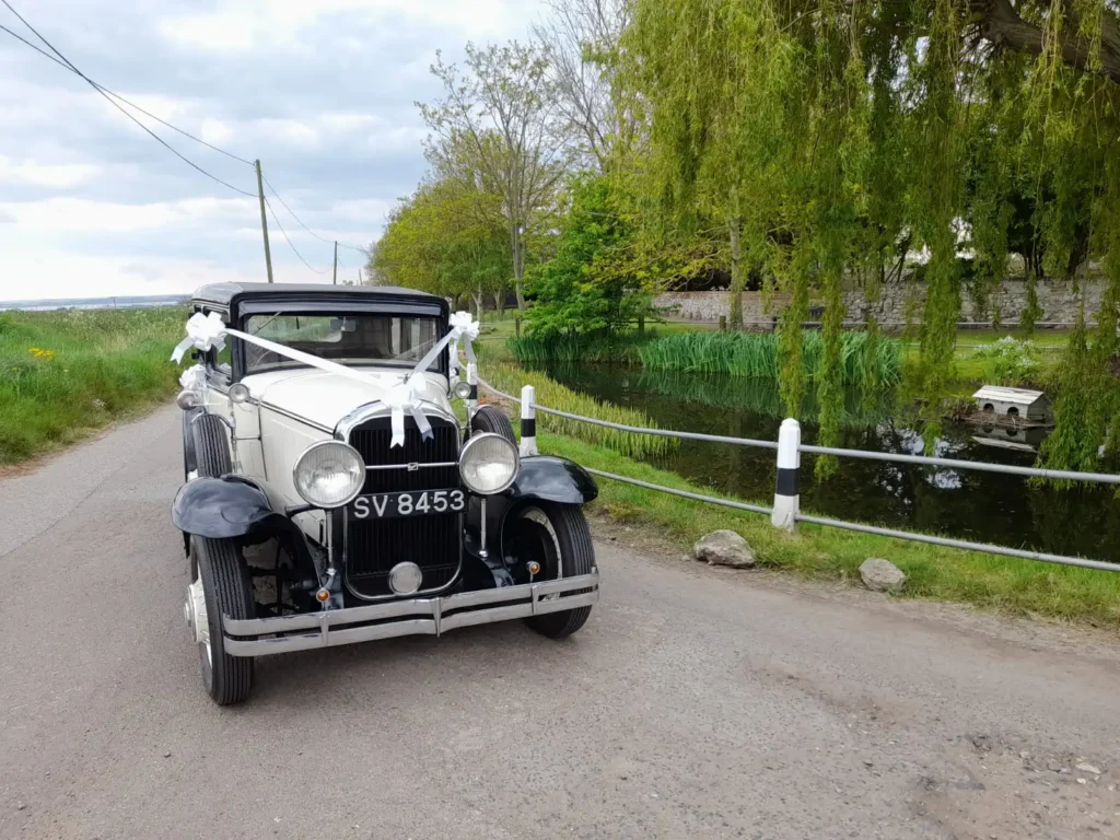 White Vintage Buick Wedding Car by lake