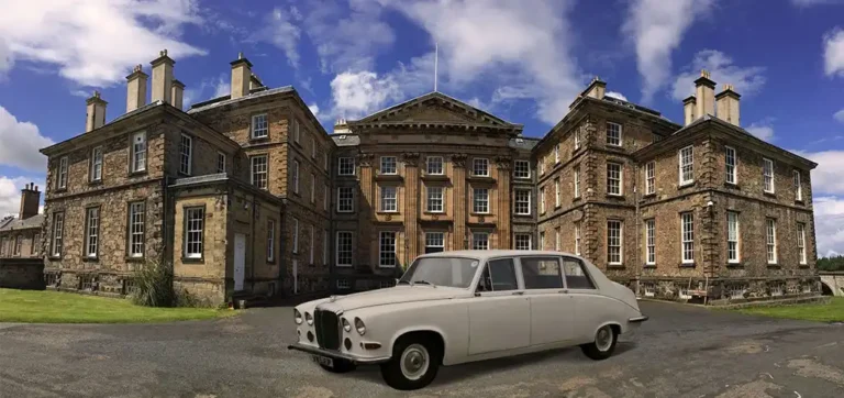 White 1979 Daimler DS420 Limousine in front of a stately mansion