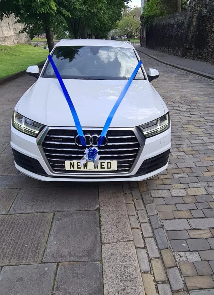 White Audi Q7 front view with blue wedding ribbon