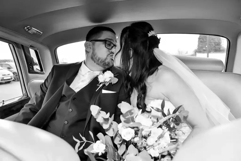 Newly weds kiss in Rolls Royce Wedding Car
